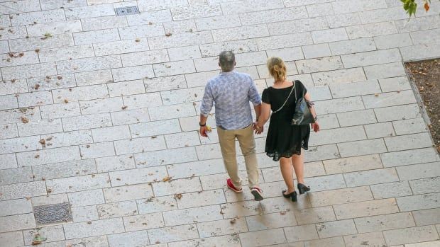 Aerial view of a couple holding hands and walking down the street