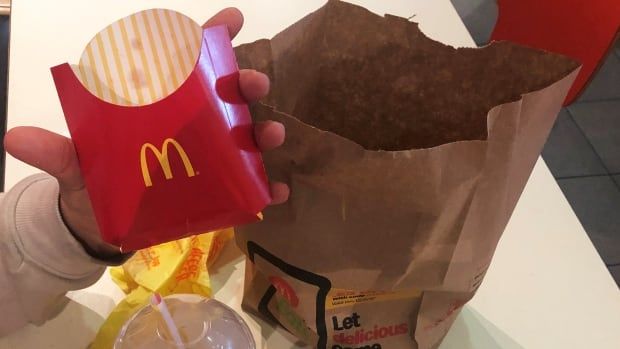 A McDonald's customer shows his empty french fries box at the fast-food chain.