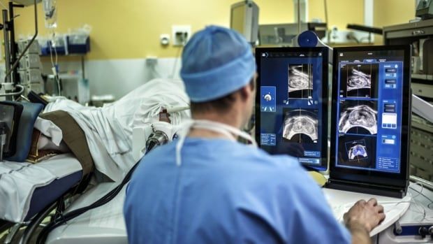 A surgeon sitting in front of screens of a Focal One device performs a robot-assisted prostate tumorectomy using ultrasound imaging on April 10, 2014 at the Edouard Herriot hospital in Lyon, center France.