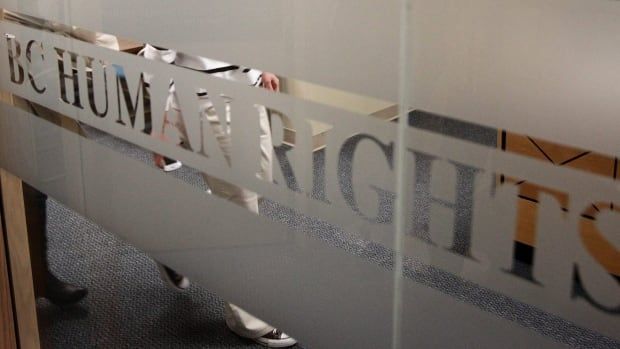 A rectangular sign in white and gold says B.C. Human Rights Tribunal.