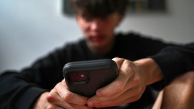 A teenager uses his mobile phone to access social media, Sydney, Wednesday, Nov. 13, 2024.