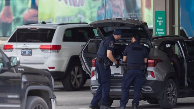 Canada Border Services Agency officers investigate a vehicle crossing at the Niagara Falls International Rainbow Bridge in Niagara Falls, Ontario Friday, June 7, 2024. CBSA workers across the country could take job action today unless a deal is reached before the strike deadline.