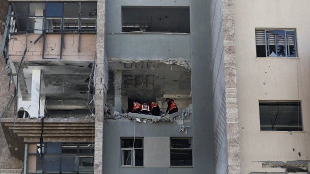 People inspect a damaged building.