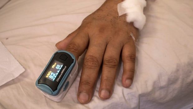 Oxygen saturation of a COVID-19 patient is monitored with a pulse oximeter.