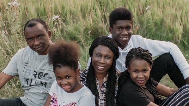 A family sits in a field of grass