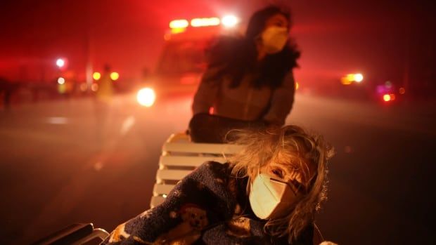 A resident of a senior centre is evacuated as the Eaton Fire approaches in Altadena, Calif. 