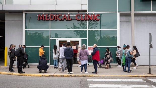 People wait outside a walk-in medical clinic.