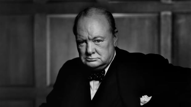 A black and white photograph of a man scowling.