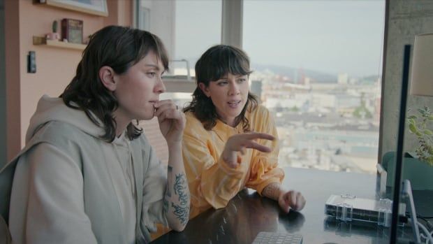 A still from the documentary Fanatical: The Catfishing of Tegan and Sara, featuring Tegan and Sara Quin looking at a computer screen.