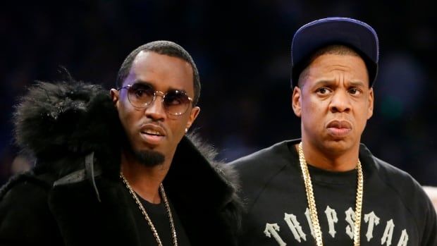 Two people are seen standing on the sidelines of a basketball game.