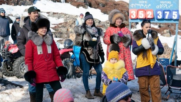 A group of women wearing coats in the snow appear in this image. 