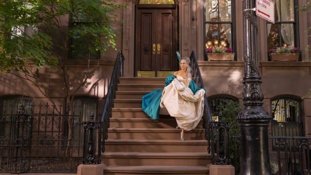 A woman in  a white gown on a front stoop