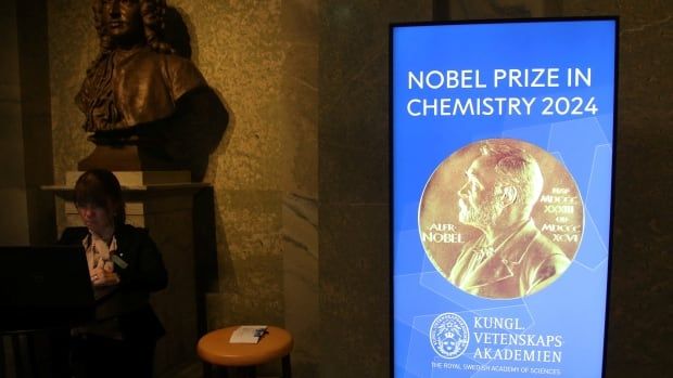 A view of the sign for the Nobel Prize in Chemistry in the Royal Swedish Academy of Sciences is shown next to a small table.