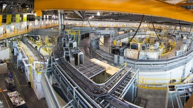 Metal tubes and pipes fill up a large room at an industrial site.