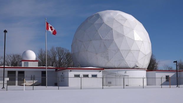 A giant golf-ball looking dome sits atop several small buildings. 