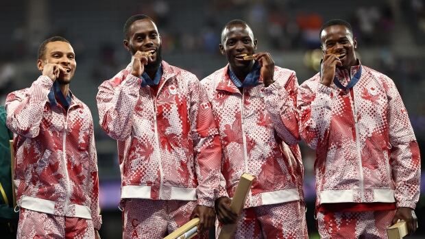 Men's relay team poses with their medals.