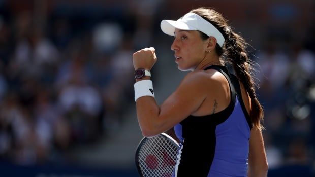 A tennis player pumps her fist.