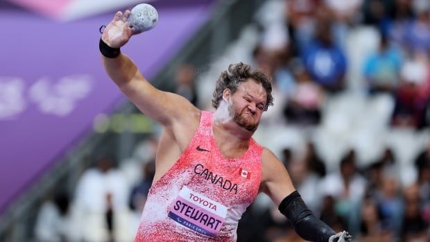 A male shot putter representing Canada launches a throw.