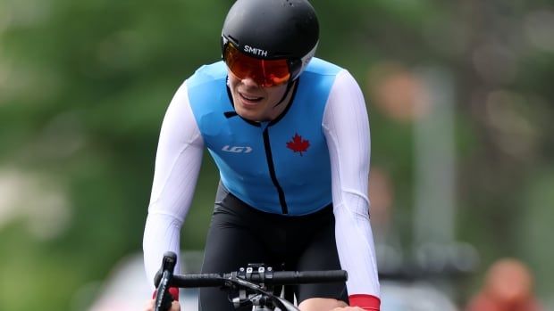 A male road tricyclist races on a time trial course.