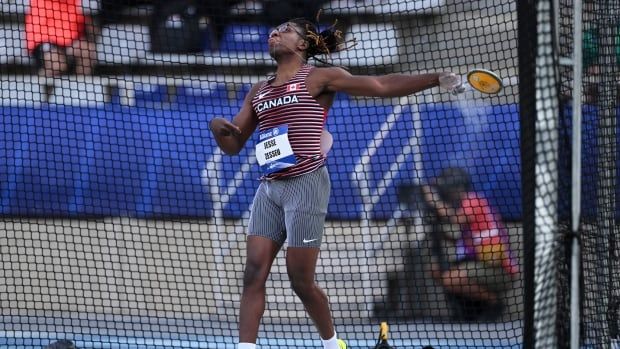 A male discus competitor launches a throw with his left hand.