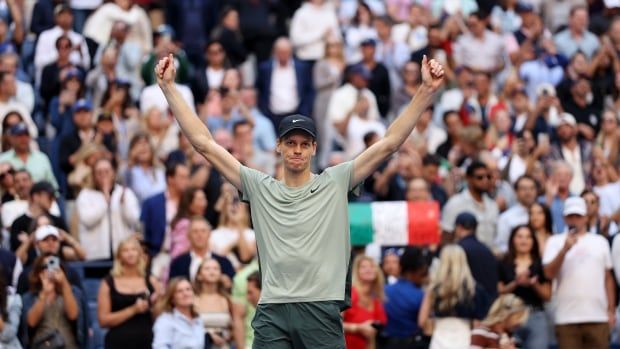 A male tennis player celebrates after clinching a victory.