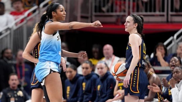 Two women basketball players on the court.