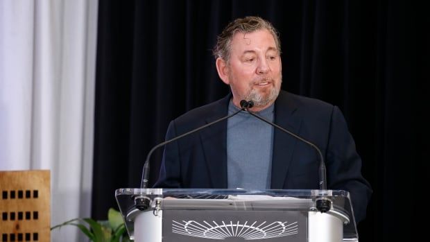 A man is seen speaking behind a pulpit.