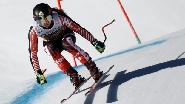 A female alpine skier races down a course during a super-G race.