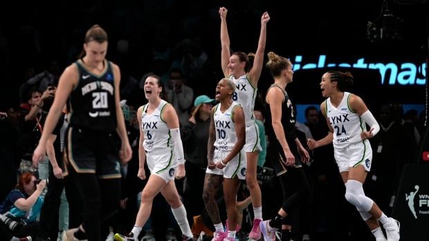 Women's basketball players celebrate.