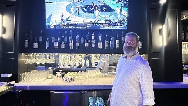 Josh Pehlke works the bar at Signature Bar & Restaurant in Chicago. On the television in the background is Game 2 of the WNBA Finals between New York Liberty and Minnesota Lynx on Oct. 13, 2024.