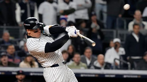 A men's baseball player makes contact on a swing.