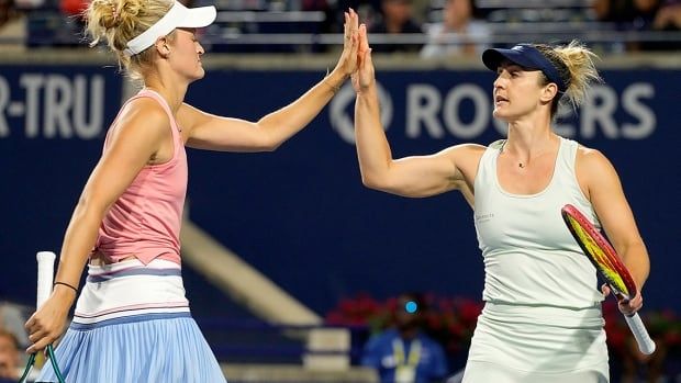 Canadian women's tennis player Gabriela Dabrowski high fives teammate Erin Routliffe of New Zealand as they force the tiebreaker with American opponents Desirae Krawczyk and Caroline Dolehide during doubles final action at the National Bank Open in Toronto on Aug. 12, 2024