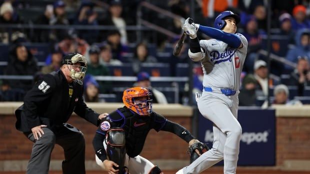 A men's baseball player watches the ball after a hit.