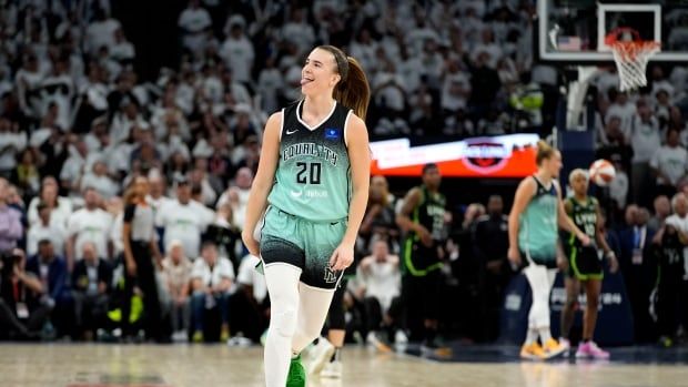 A women's basketball player celebrates.