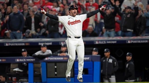 A men's baseball player jumps in celebration.