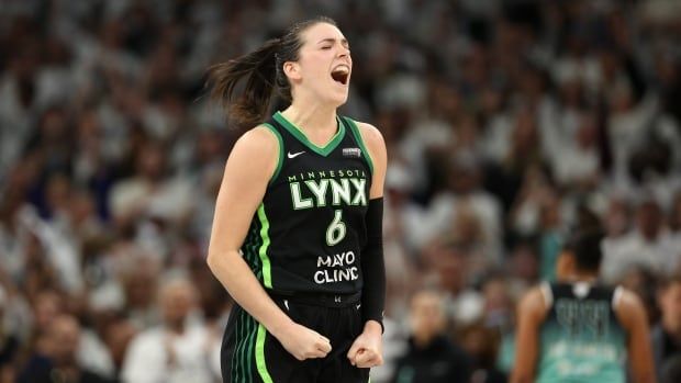 A women's basketball player celebrates.