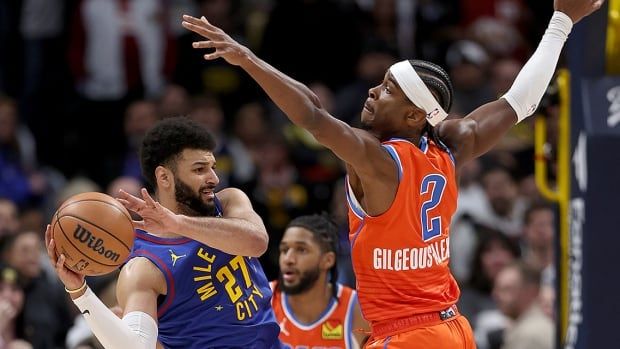 Jamal Murray of the Denver Nuggets is guarded by fellow Canadian Shai Gilgeous-Alexander of the Oklahoma City Thunder during NBA regular-season action at Ball Arena on Dec. 16, 2023 in Denver, Colorado. 