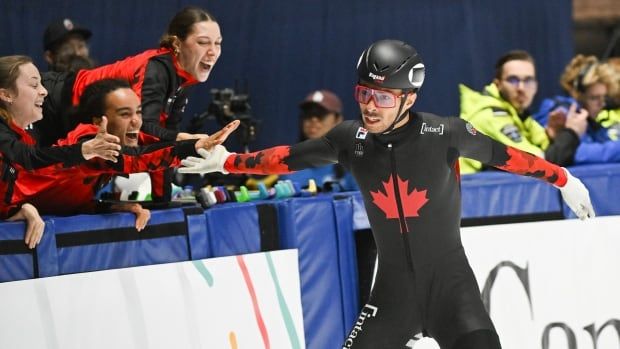 Canadian male short track speed skater William Dandjinou celebrates with teammates after Canada won the 5000-metre relay final race at the ISU World Cup Short Track Speedskating event in Montreal, Sunday, Oct. 22, 2023.