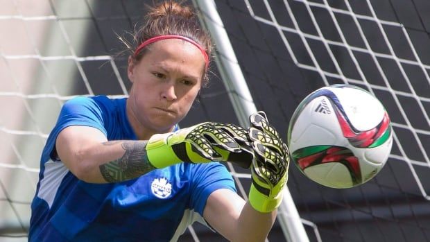 A goalkeeper saves a ball