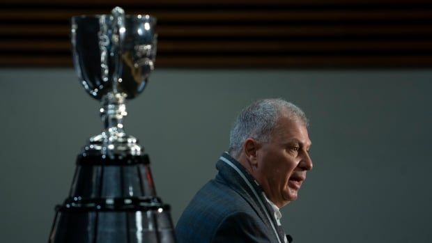 A man beside a trophy.