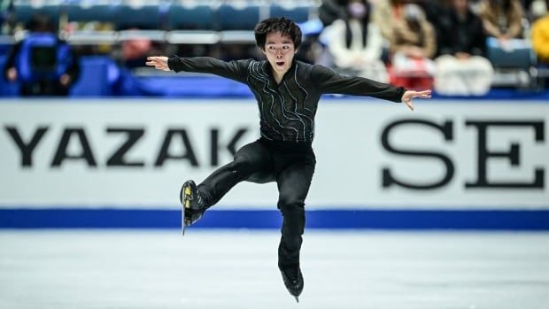 A men's figure skater is shown mid-jump.