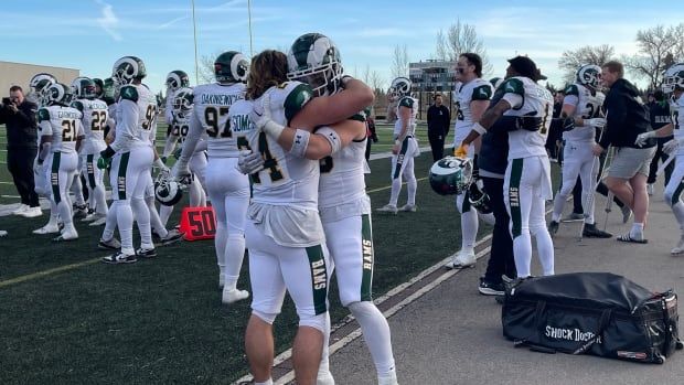 Two football players hug