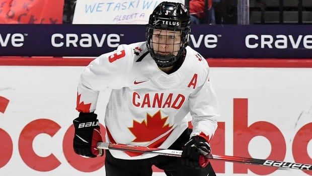 A hockey player skates up ice.