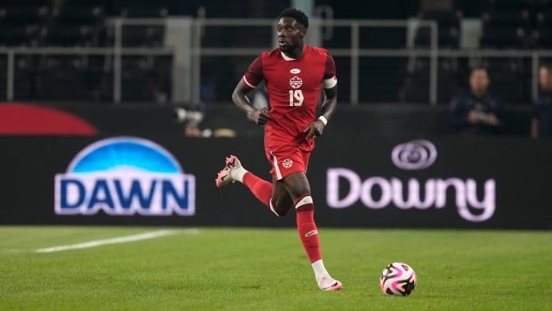 A male soccer player is seen with the ball during a game.