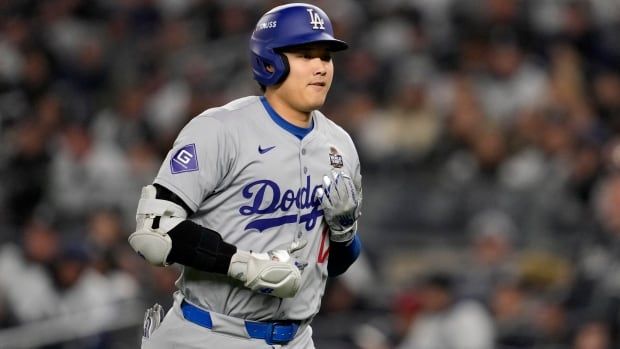 A male baseball player is seen running.