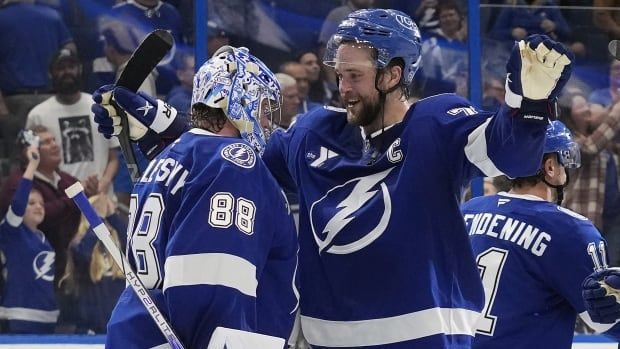 A player in blue hugs his goaltender after the game.