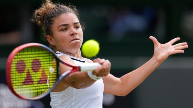 Italian female tennis player plays a forehand return to a Croatian player during their semifinal match at the Wimbledon tennis championships in London, Thursday, July 11, 2024.