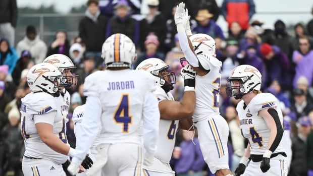 Laurier Golden Hawks male player, second from right, celebrates with his teammates after scoring a touchdown against the Bishop's Gaiters during first half Saturday in U Sports Uteck Bowl football action in Lennoxville, Que., Saturday Nov. 16, 2024.