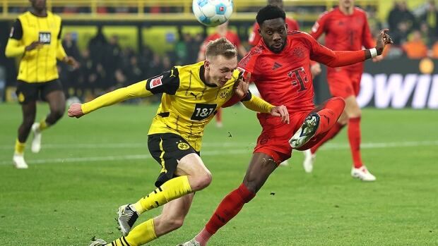 Bayern Munich soccer player Alphonso Davies, from Canada, competes for possession of the ball with Maximilian Beier of Borussia Dortmund during a Nov. 30, 2024 Bundesliga match at Signal Iduna Park in Dortmund, Germany.