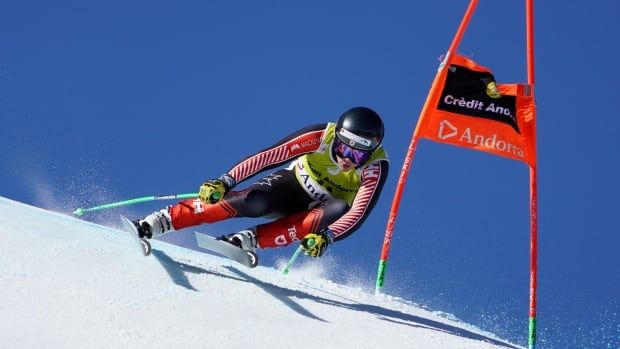 A male alpine skier speeds around a pole marker.